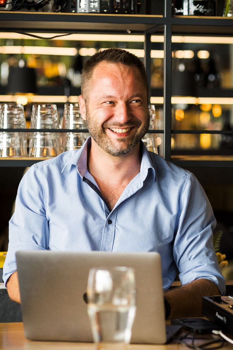DJ Andi Apitzsch lächelnd am Laptop